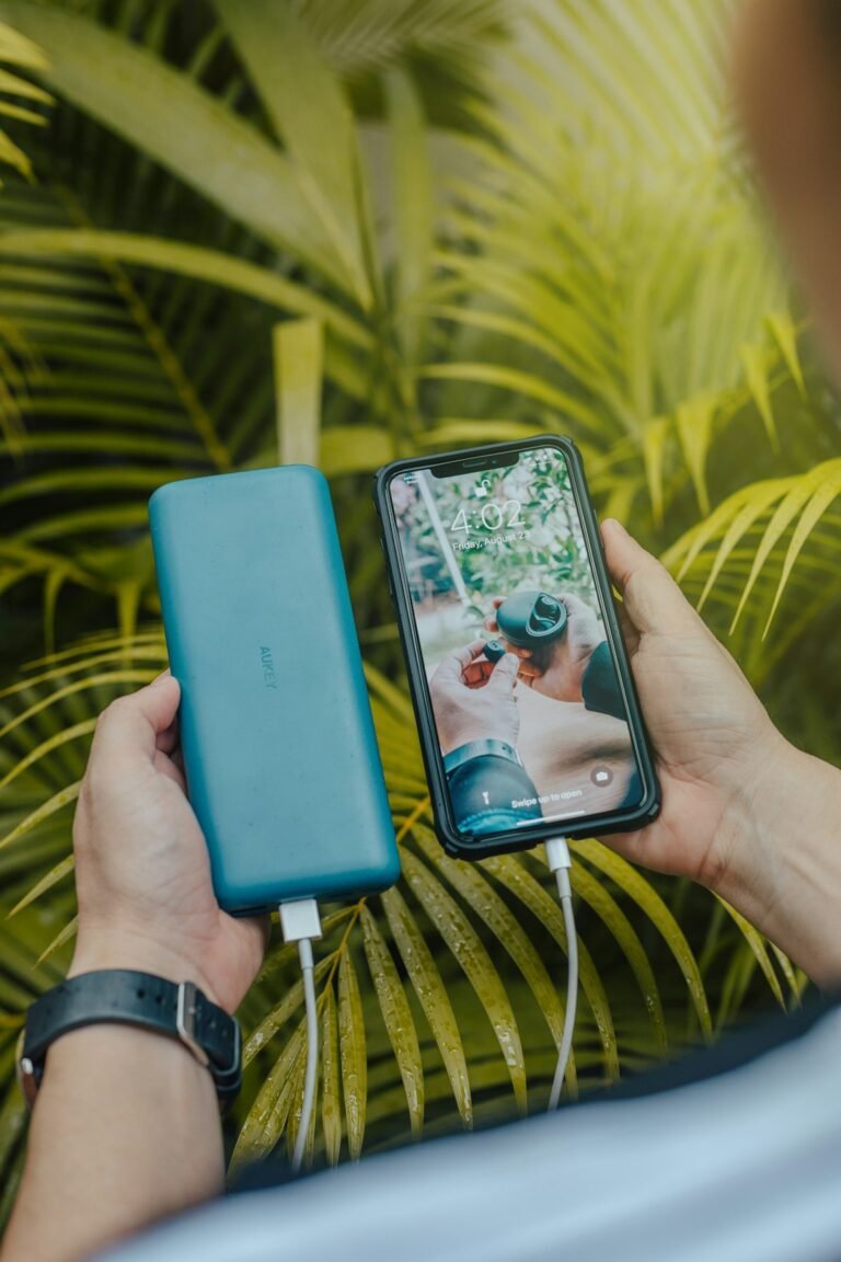 A portable power bank charging a smartphone on a desk